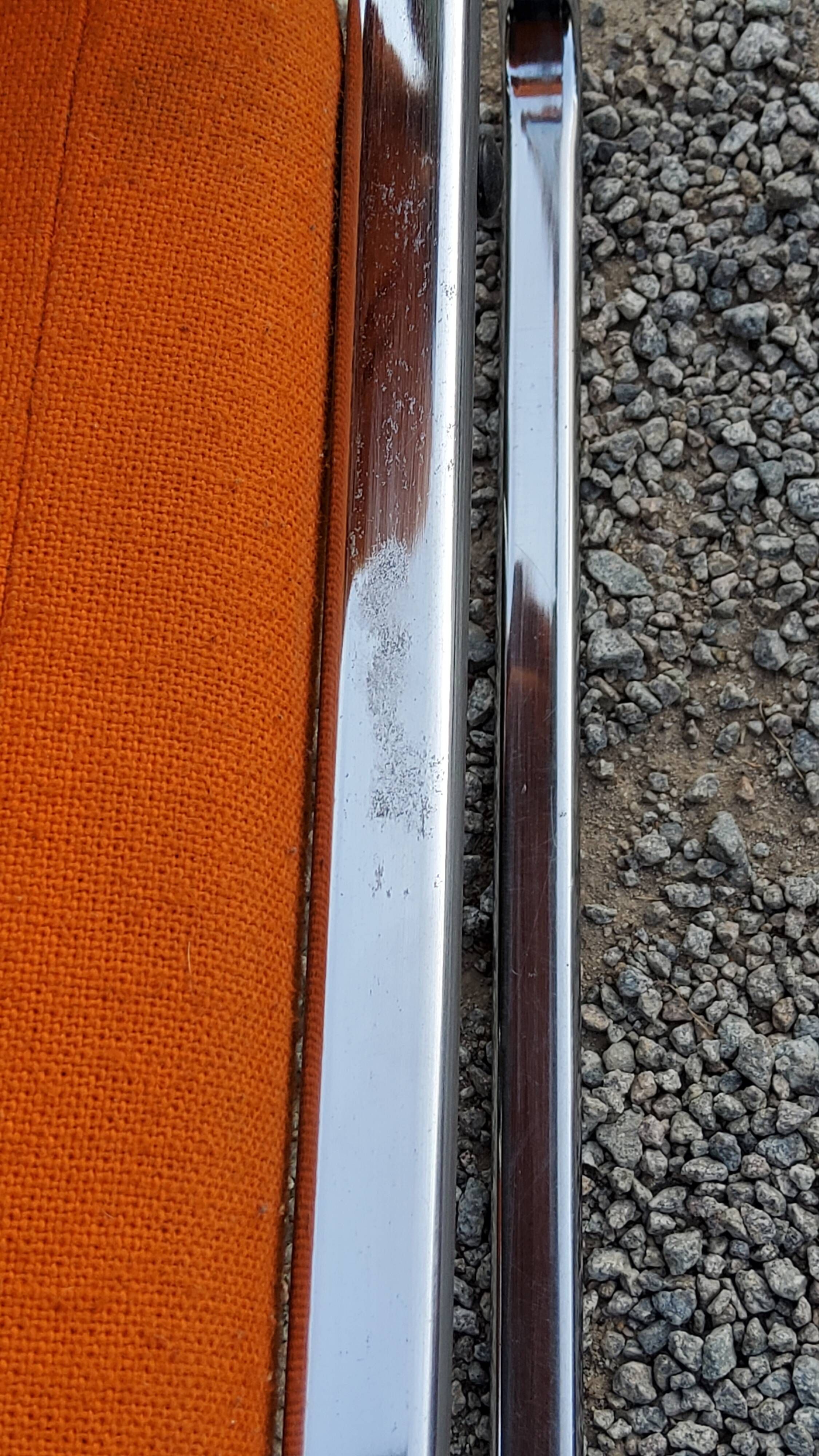 Pair of designer armchairs in orange fabrics and chrome tubes from the 70s