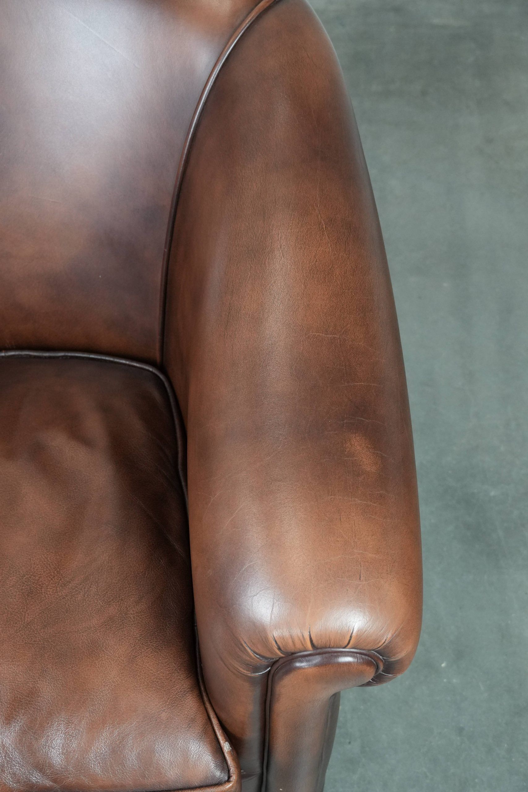 Great luxurious brown cowhide club armchair with matching piping