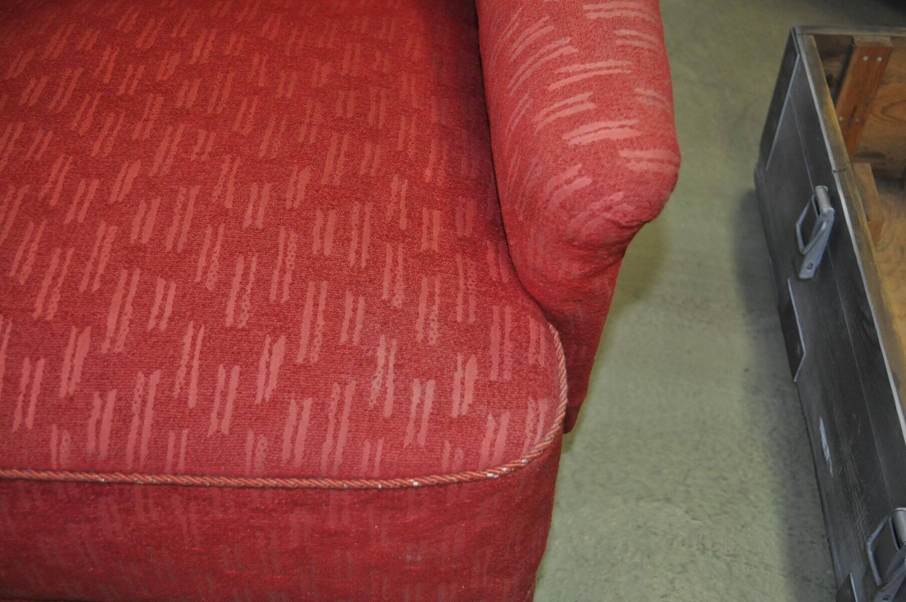 Pair of Mid-Century armchairs in red and brown fabric with dark wooden legs.