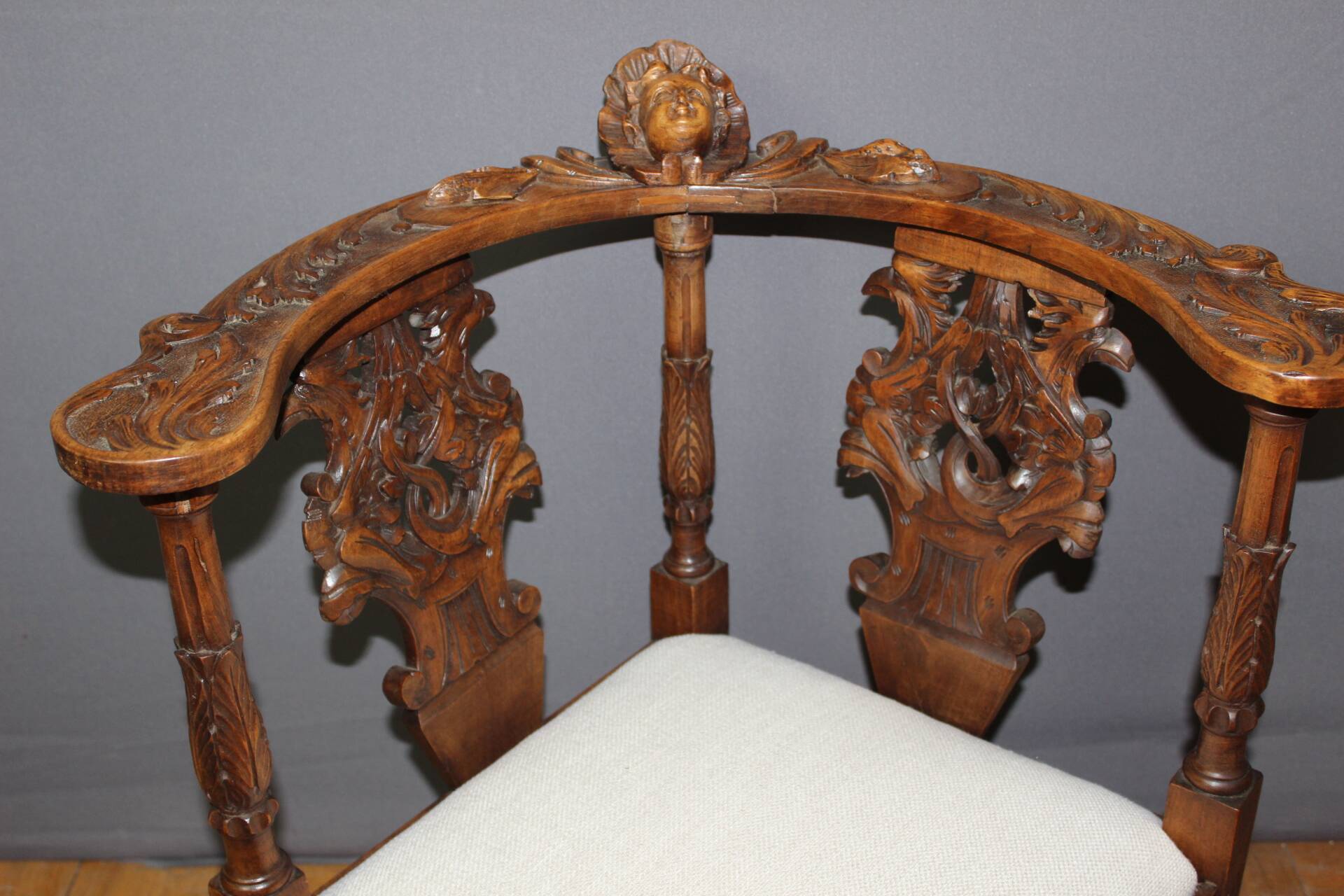 19th century walnut corner armchair with carved angel decoration