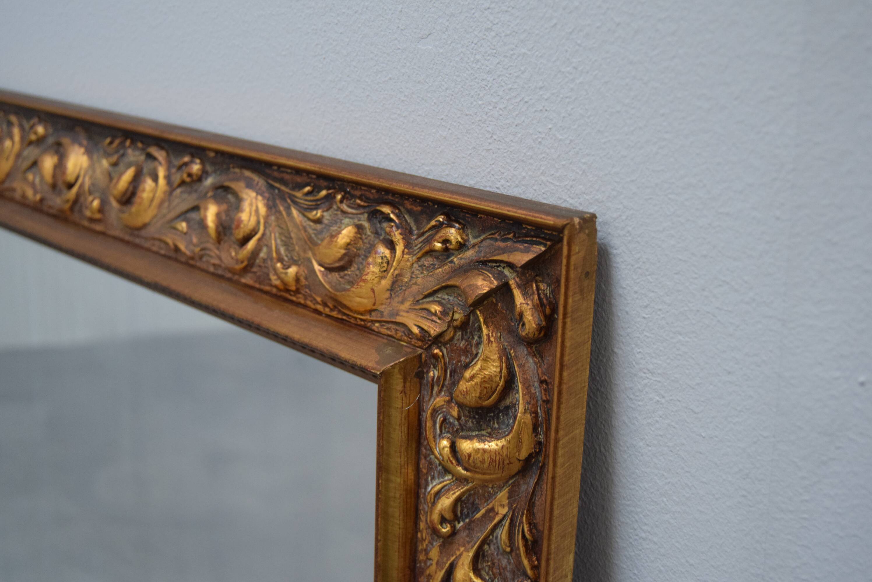 wall mirror in a decorative wooden frame.