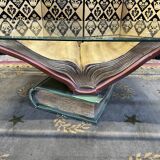 Coffee table with a base in the shape of books