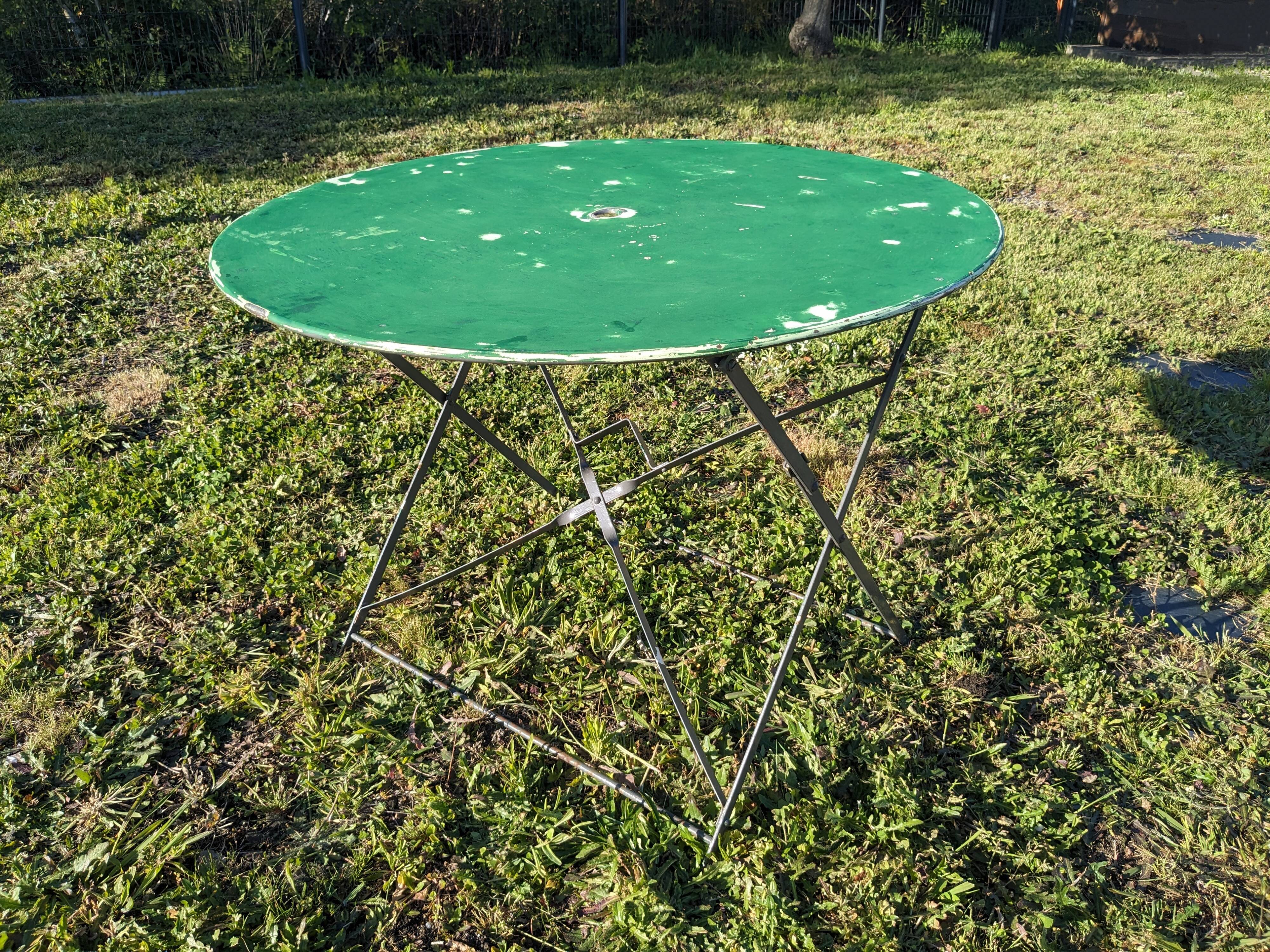 Antique round folding garden table with a green patina.