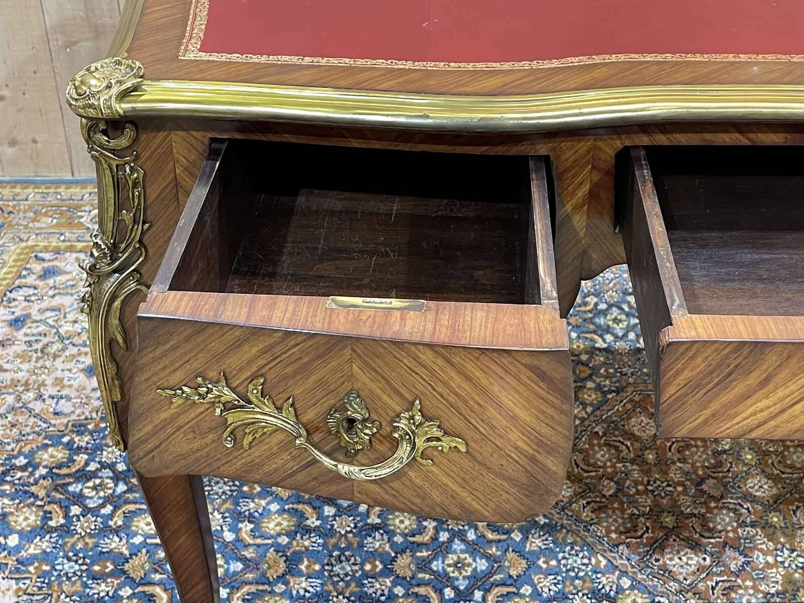 Bureau plat de style régence en placage de bois de rose, travail des années 1950