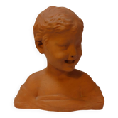 Terracotta bust of a smiling little boy.