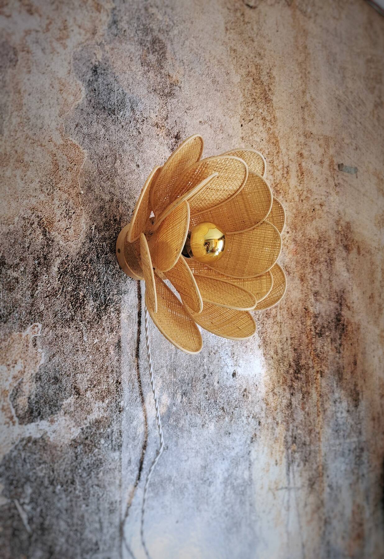 Flower wall light made of rattan and raffia petals