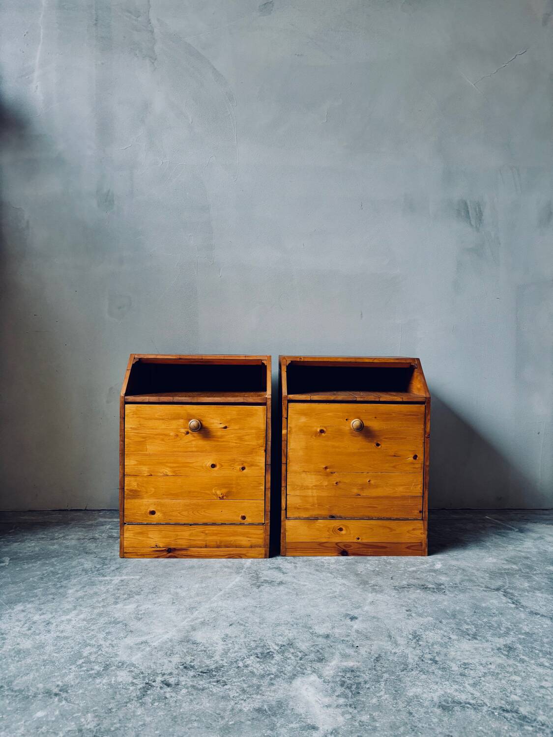 Pair of handcrafted solid wood bedside tables with drop-down doors.