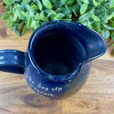 Blue ceramic pitcher with vintage artisan inscription decoration.