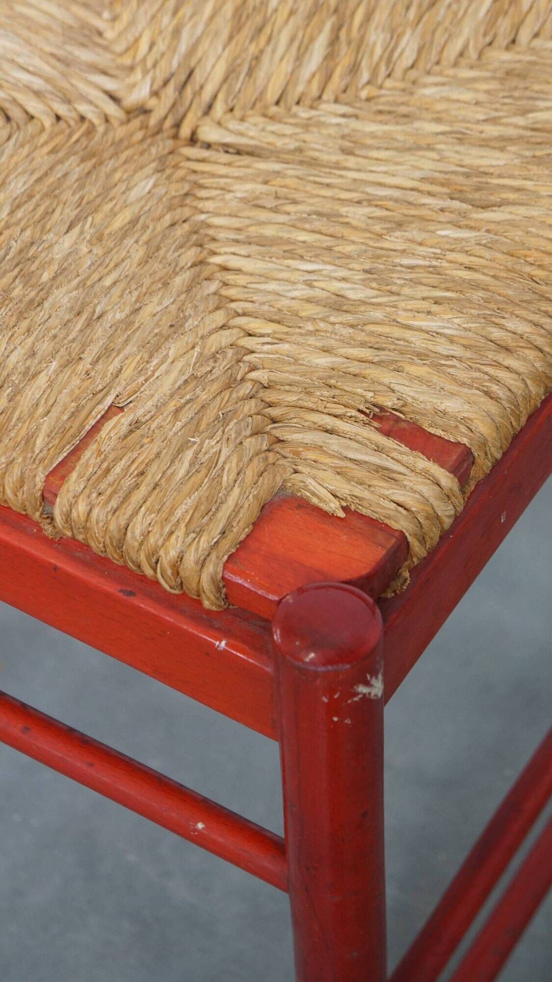 Vintage 1970s red wooden chair with a woven wicker seat