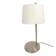 Large brushed metal table lamp with an ecru shade.