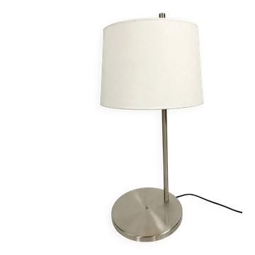 Large brushed metal table lamp with an ecru shade.