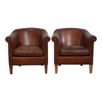 Set of two vintage sheep leather club armchairs with a rugged character