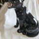 Statue of a roaring panther/leopard sitting in black glazed ceramic.