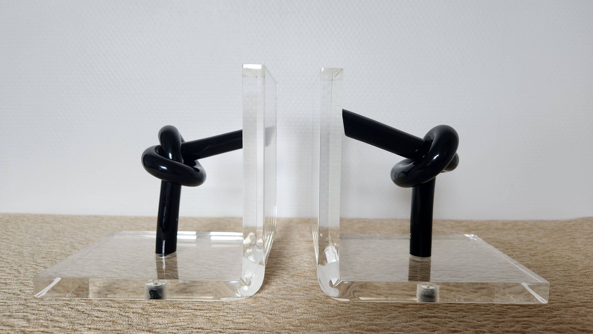 Bookends in plexiglass and knotted black tubes, 1980s design.