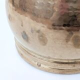 Vintage round cache-pot in hammered brass with decorative handles and patina.