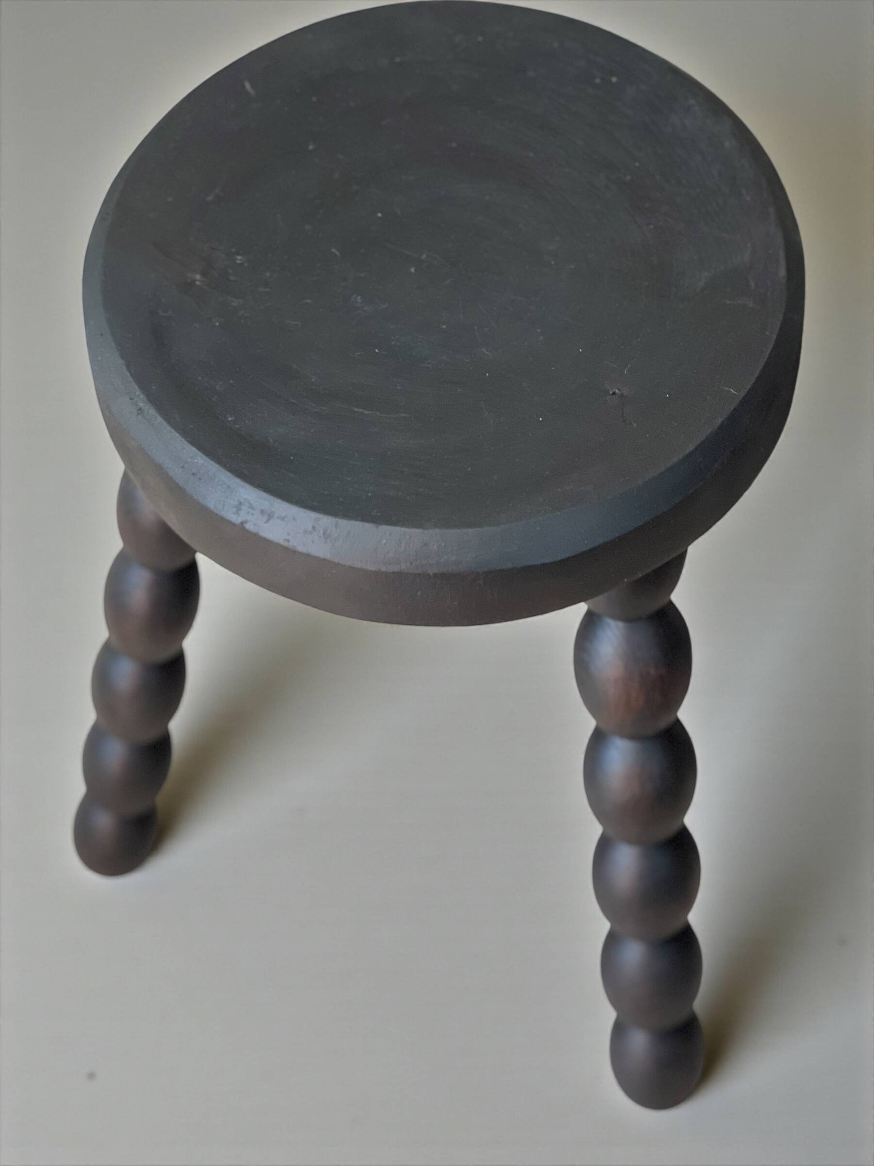 Set of side table and 2 stools, stained black wood, Circa 1950.