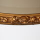 Beveled oval mirror in gilded wood