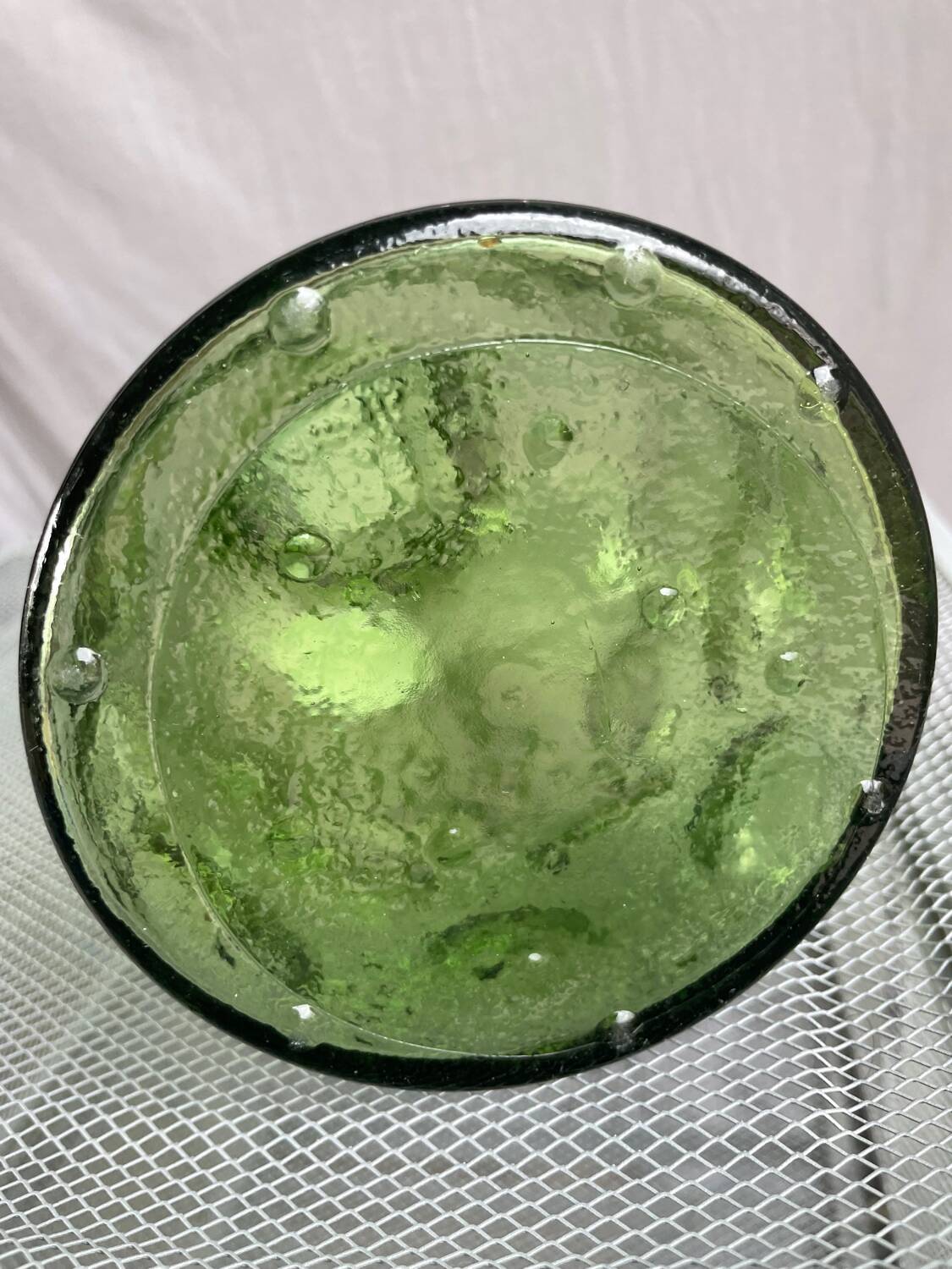 Green glass bottle with craters