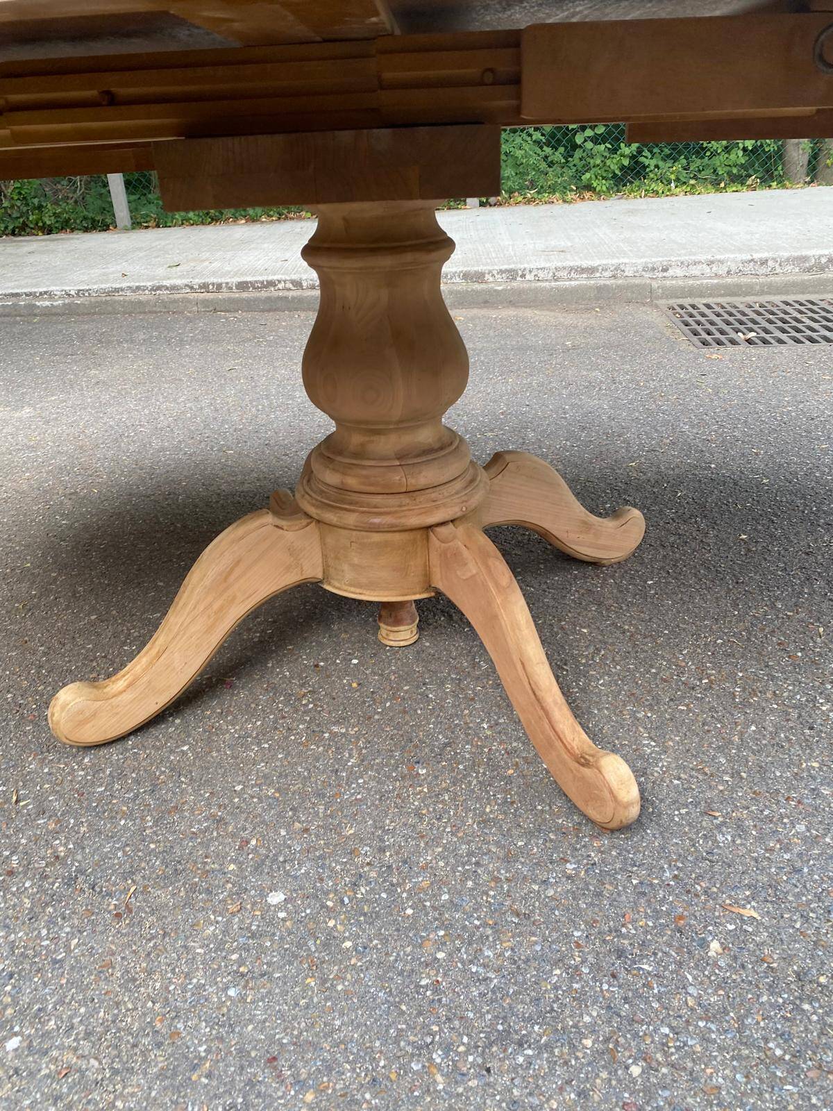 Round dining table with a central pedestal, extendable, stripped in solid walnut with 2 extensions.
