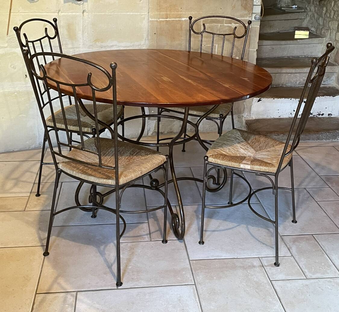 Table and four wrought iron and wood chairs.