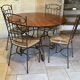 Table and four wrought iron and wood chairs.
