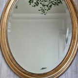 Oval mirror beveled gilded, wooden frame and stucco
