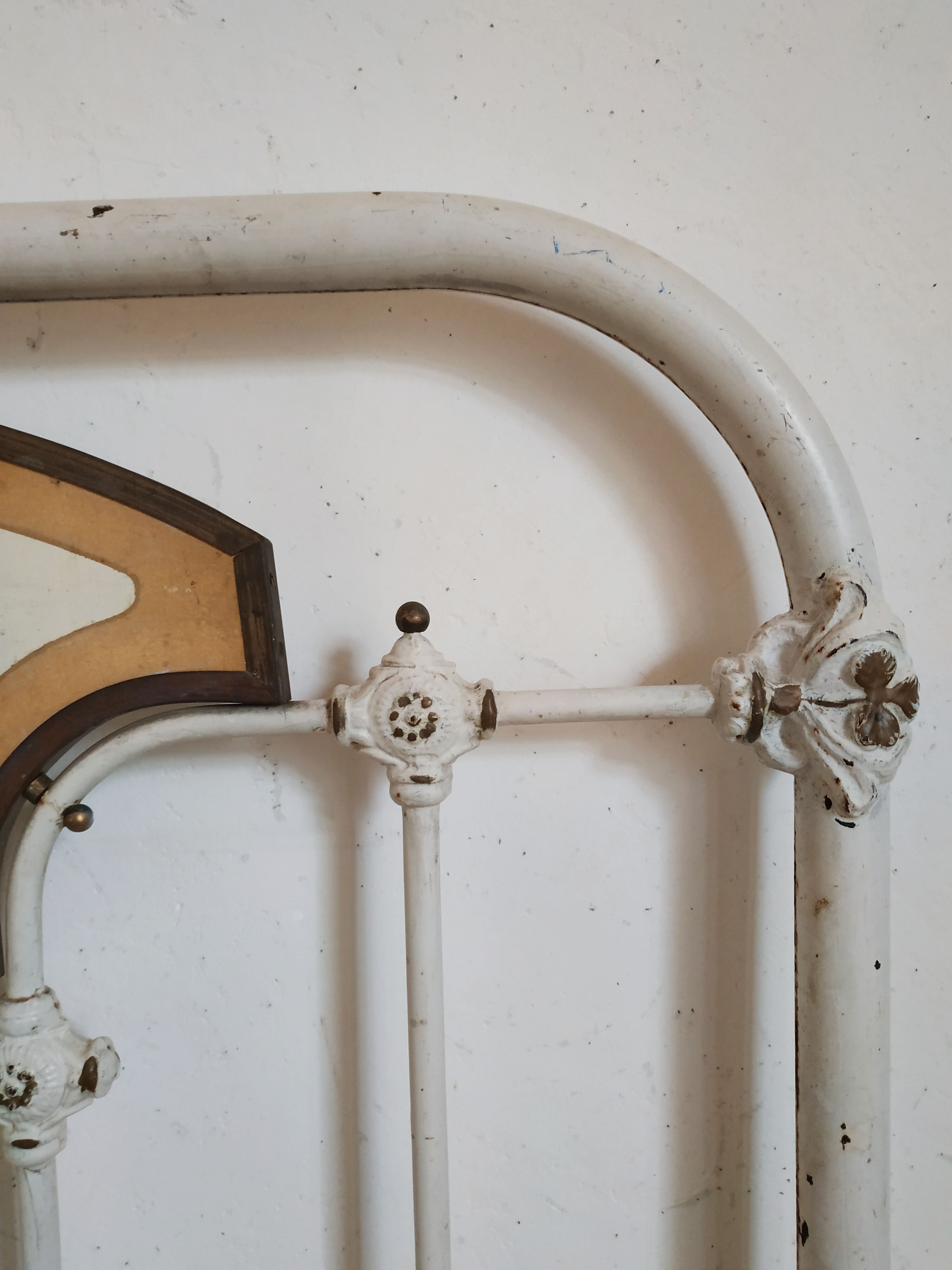 Cast-iron headboard and patinated white wood