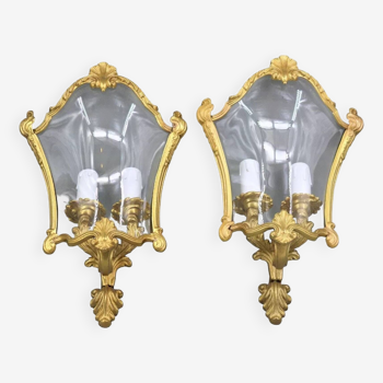 Pair of Louis XV style wall lights in bronze & curved glass