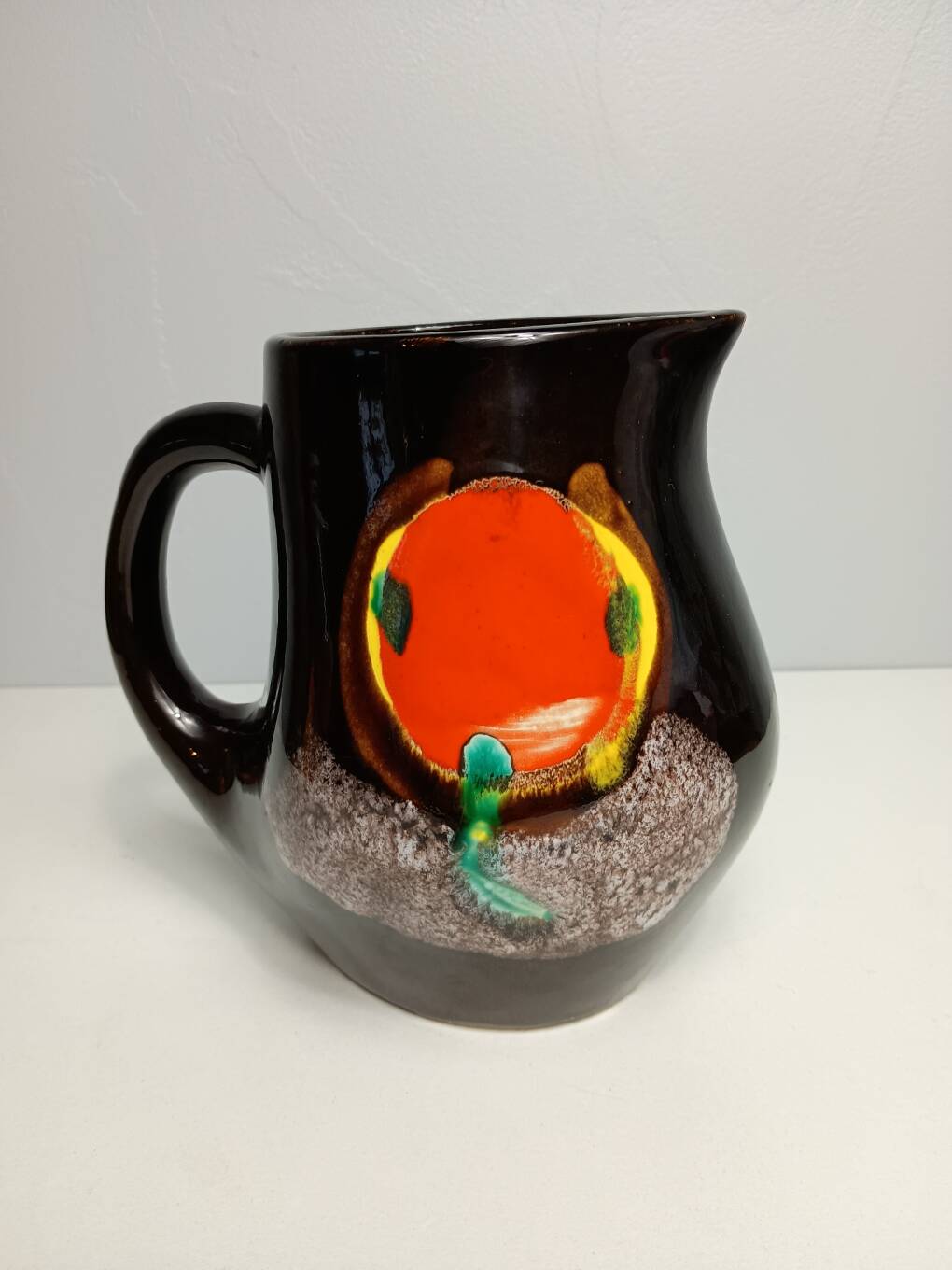 Brown ceramic pitcher with coloured patterns signed Bresse.