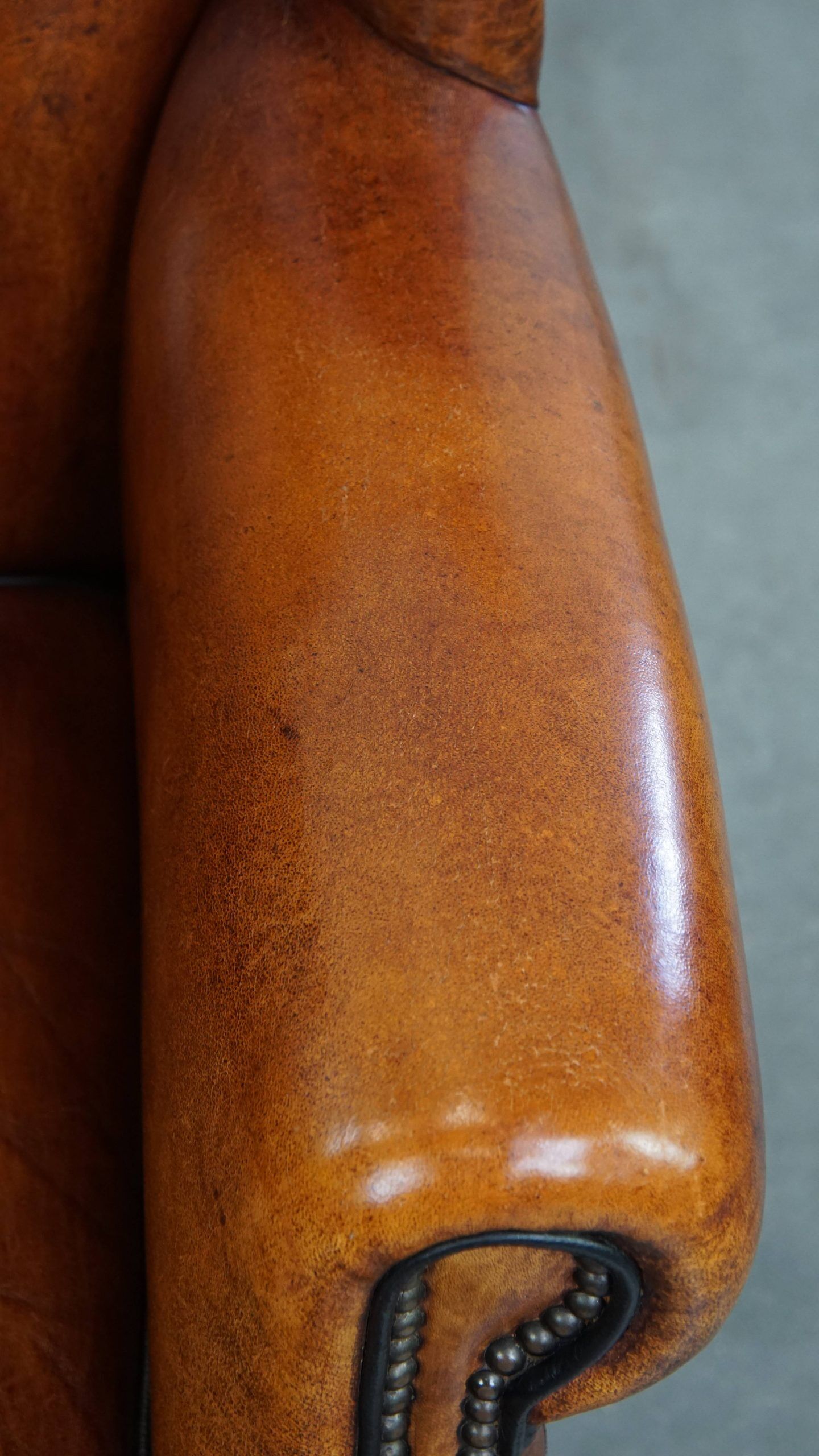 Sheepskin wingback armchair with stitching and black piping