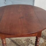 Old extendable round table in fruit wood with folding sides