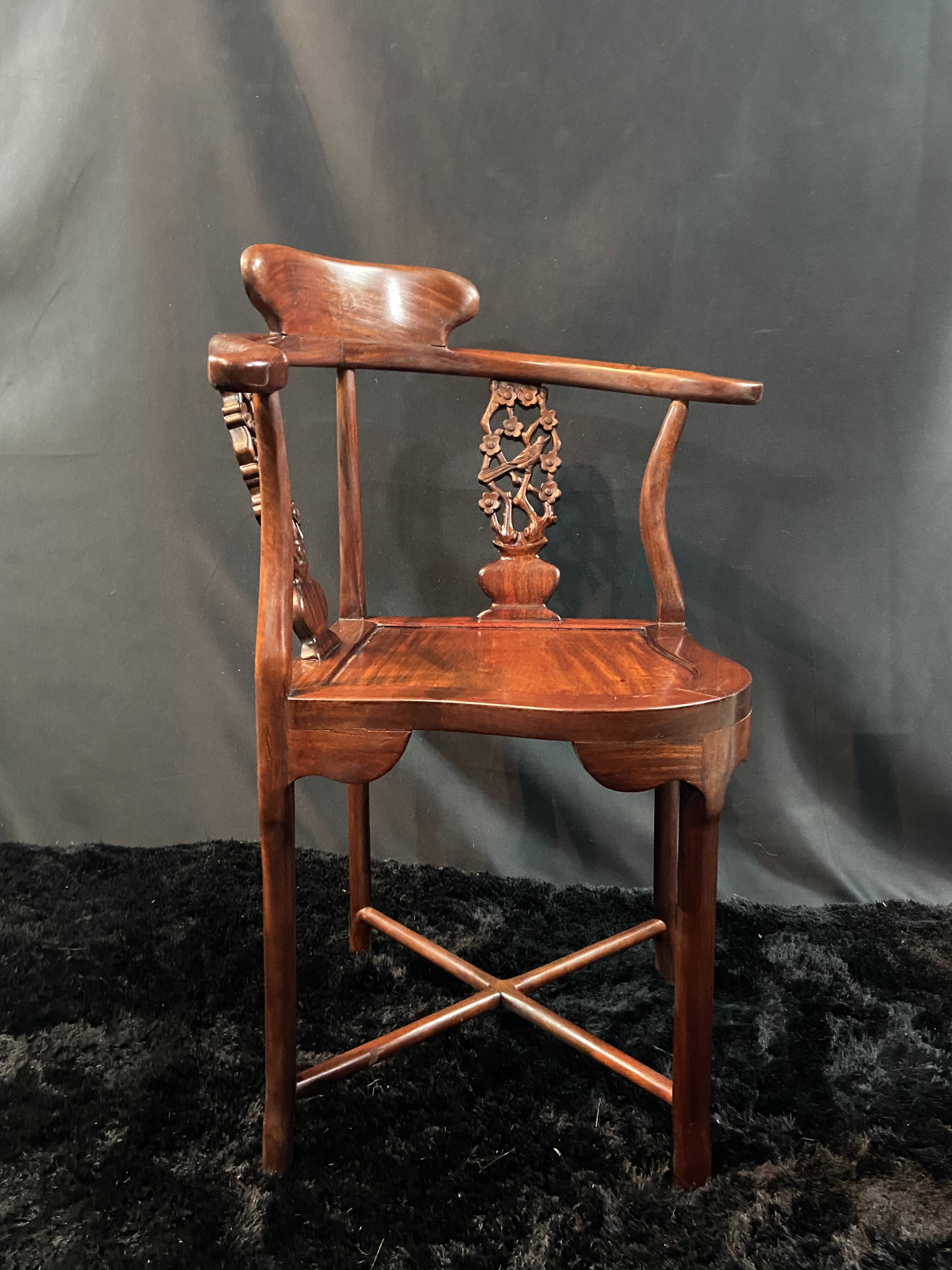 Corner armchair in solid wood with carved floral decoration featuring a bird.
