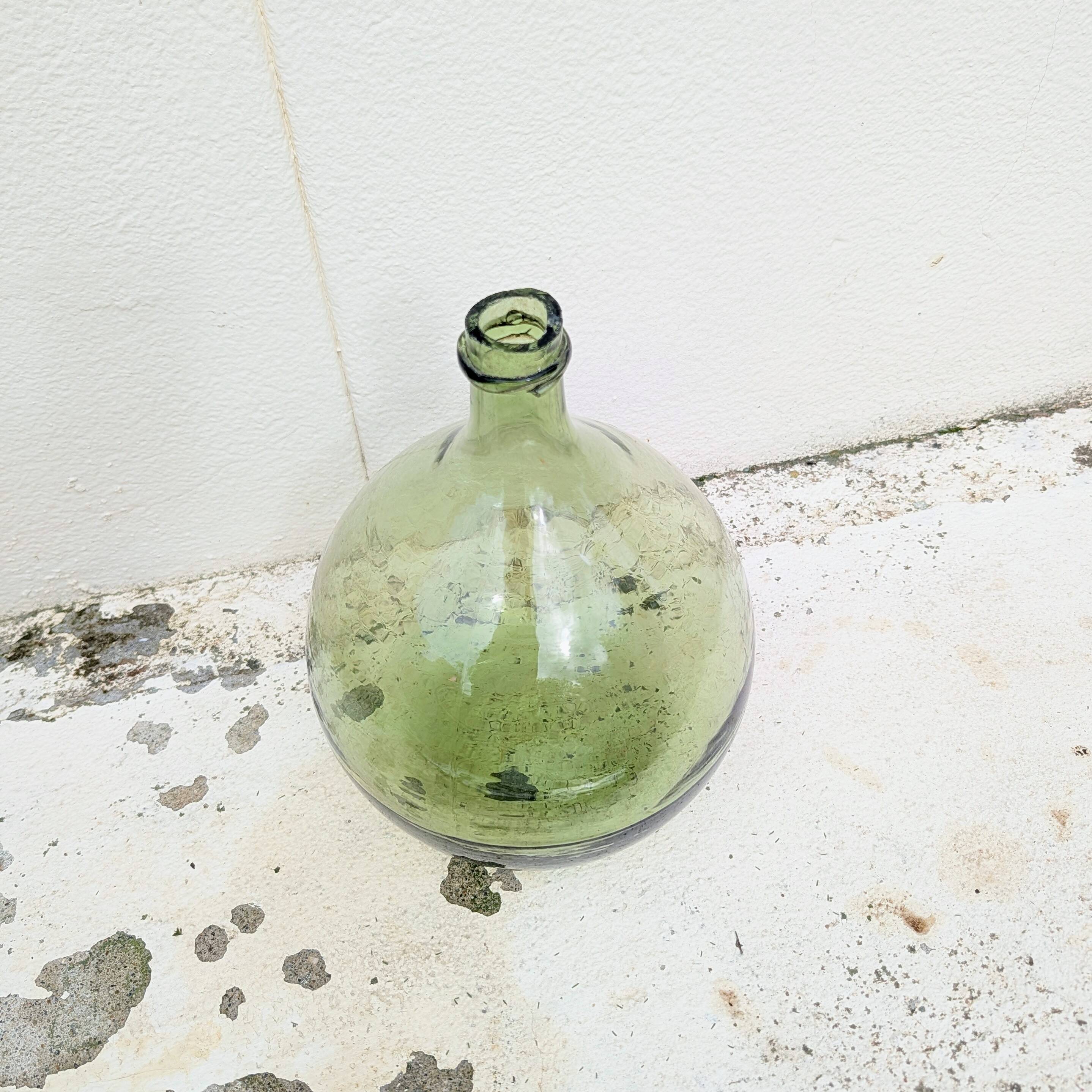 Give me a green glass jug made of blown glass.
