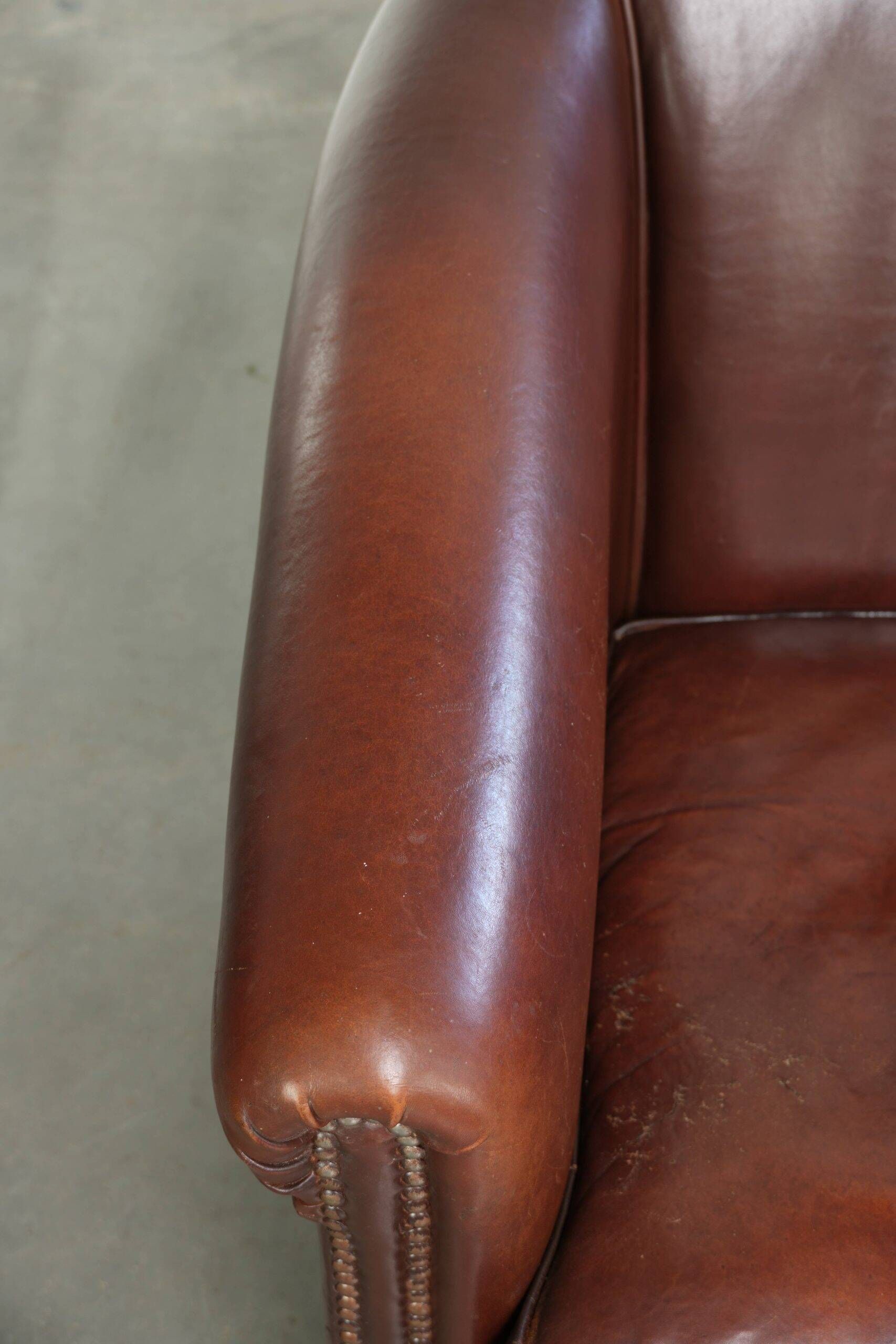 Characterful sheepskin club armchair in a dark cognac colour in English style
