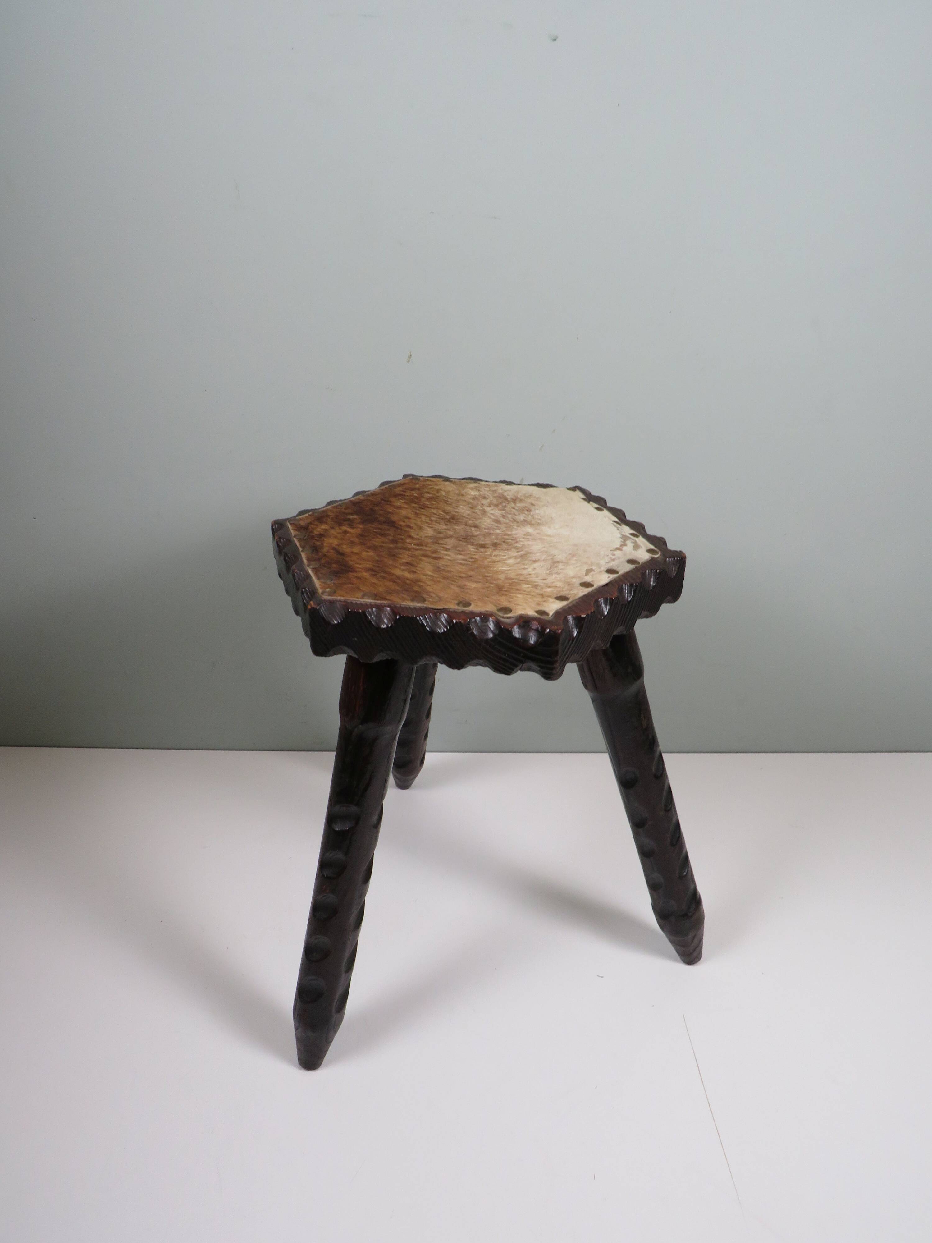 Vintage Spanish stool in carved wood with a leather seat.