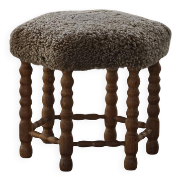 Un tabouret hexagonal en chêne, siège réhabilité en laine d'agneau, design danois des années 1950