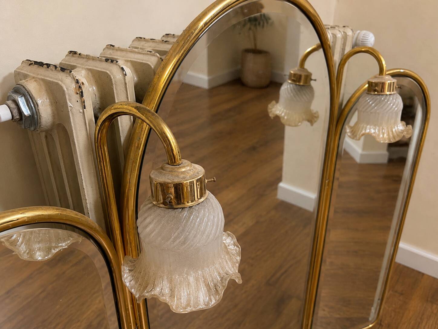 Vintage triptych mirror in brass with wall lights.