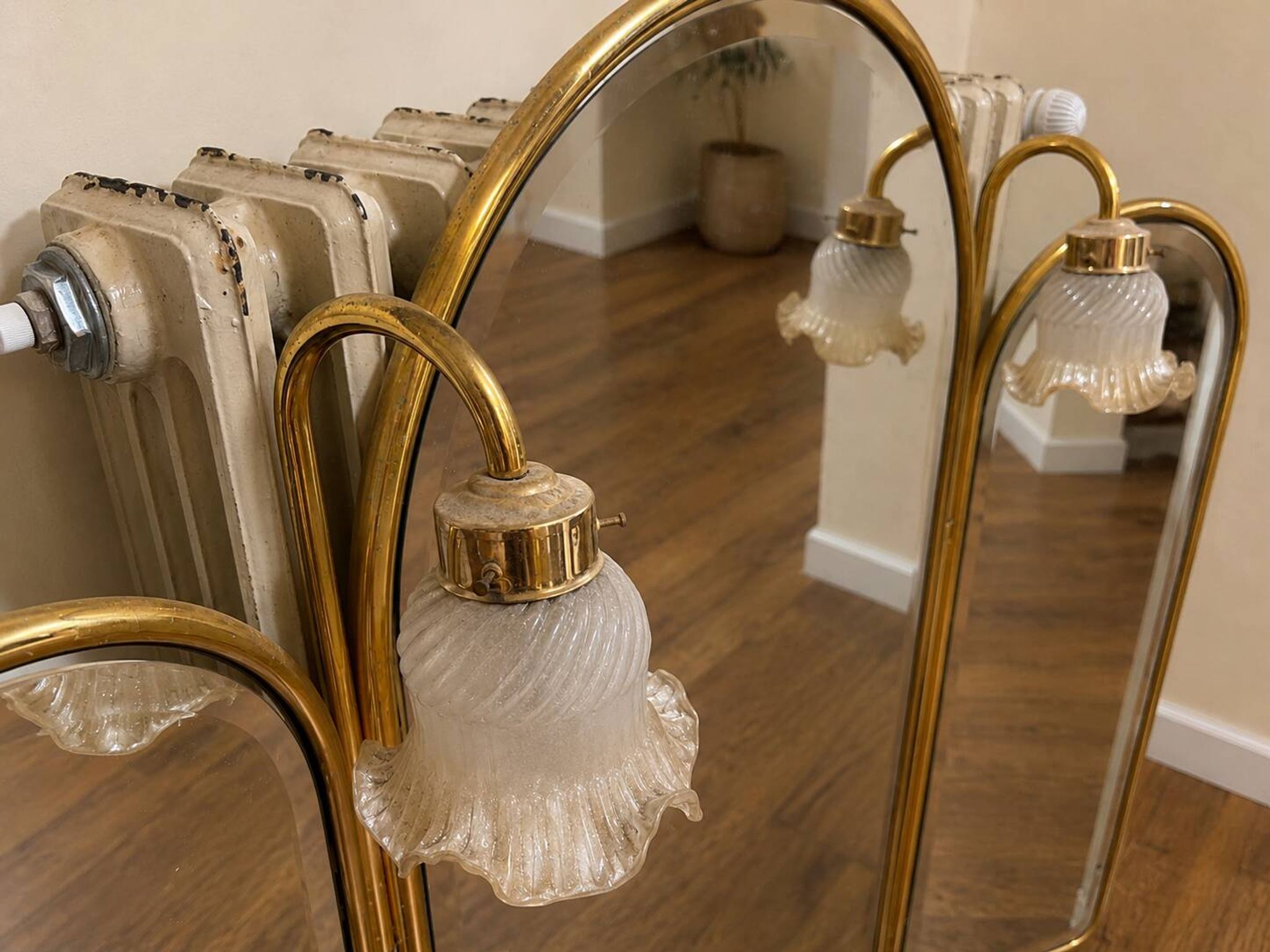 Vintage triptych mirror in brass with wall lights.