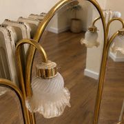 Vintage triptych mirror in brass with wall lights.