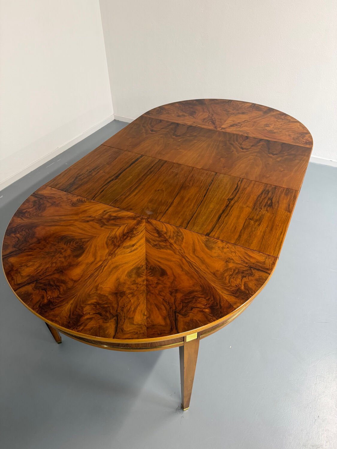 Round walnut Napoleon III extendable table with bronze top in good condition.