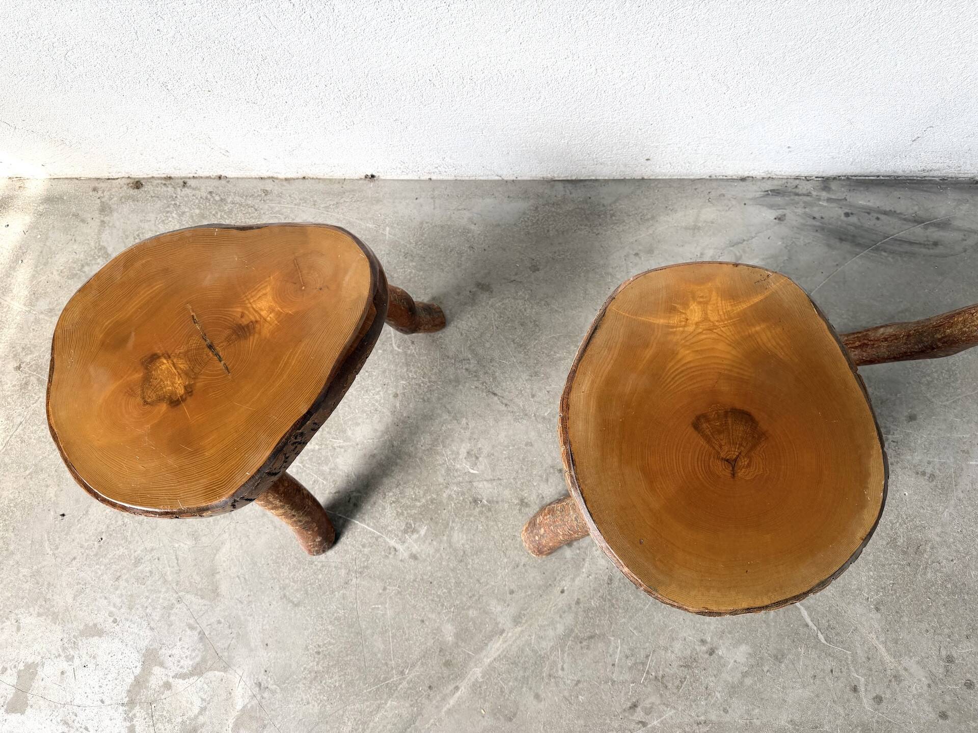 Set of three rustic solid wood tripod stools.