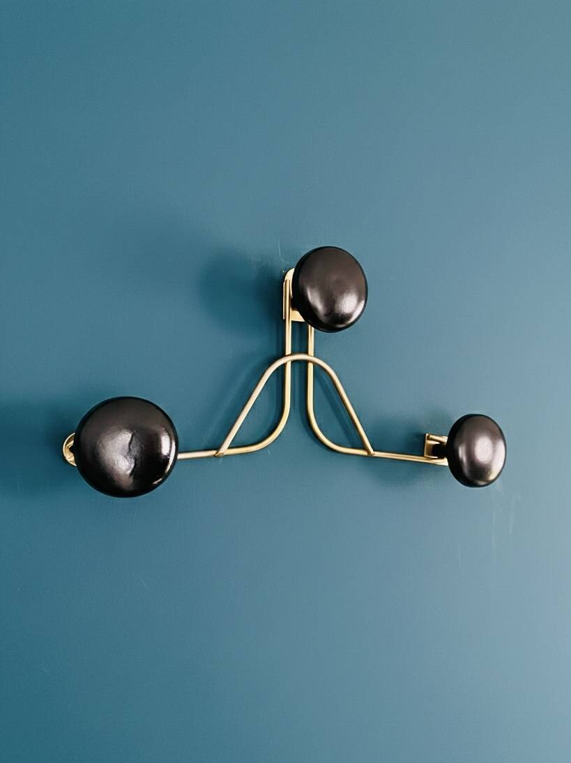 Golden brass coat rack with 3 black vintage hooks from the Mid Century 1950-60.