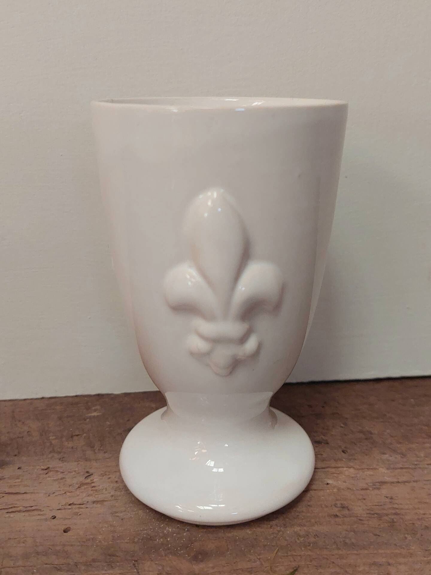 Three antique cups decorated with fleur-de-lis.