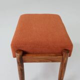 Vintage armchair and footrest in orange corduroy.