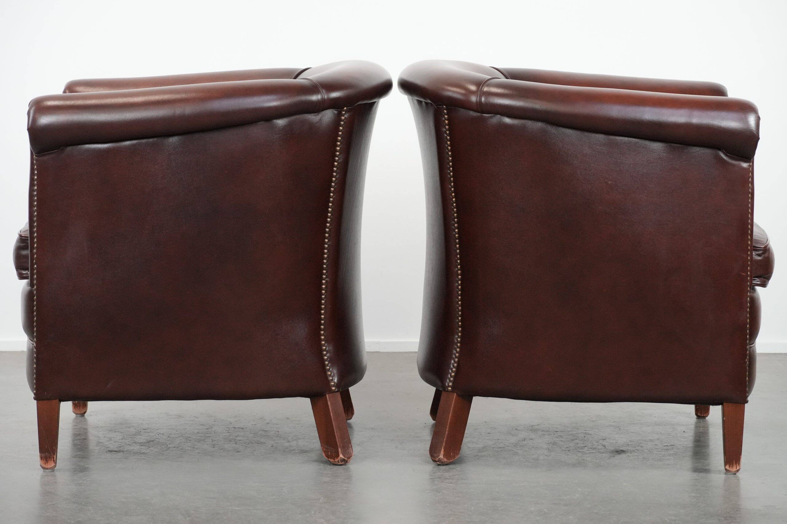 Set of two cow leather club armchairs in a luxurious red/brown colour