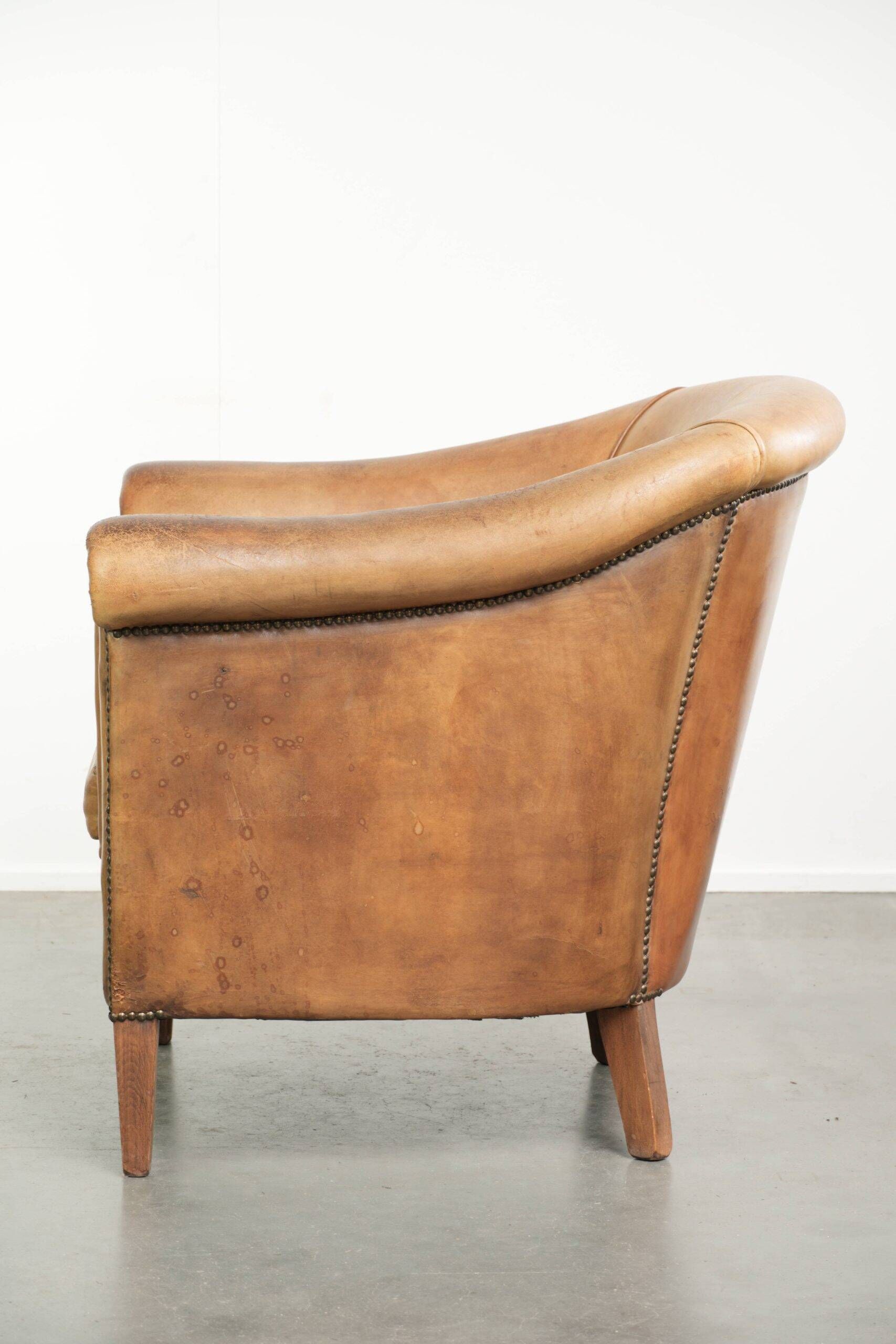 Fauteuil club en peau de mouton confortable de couleur cognac.