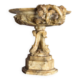 Alabaster bowl decorated with vine leaves on a base of three dolphins, circa 1880.