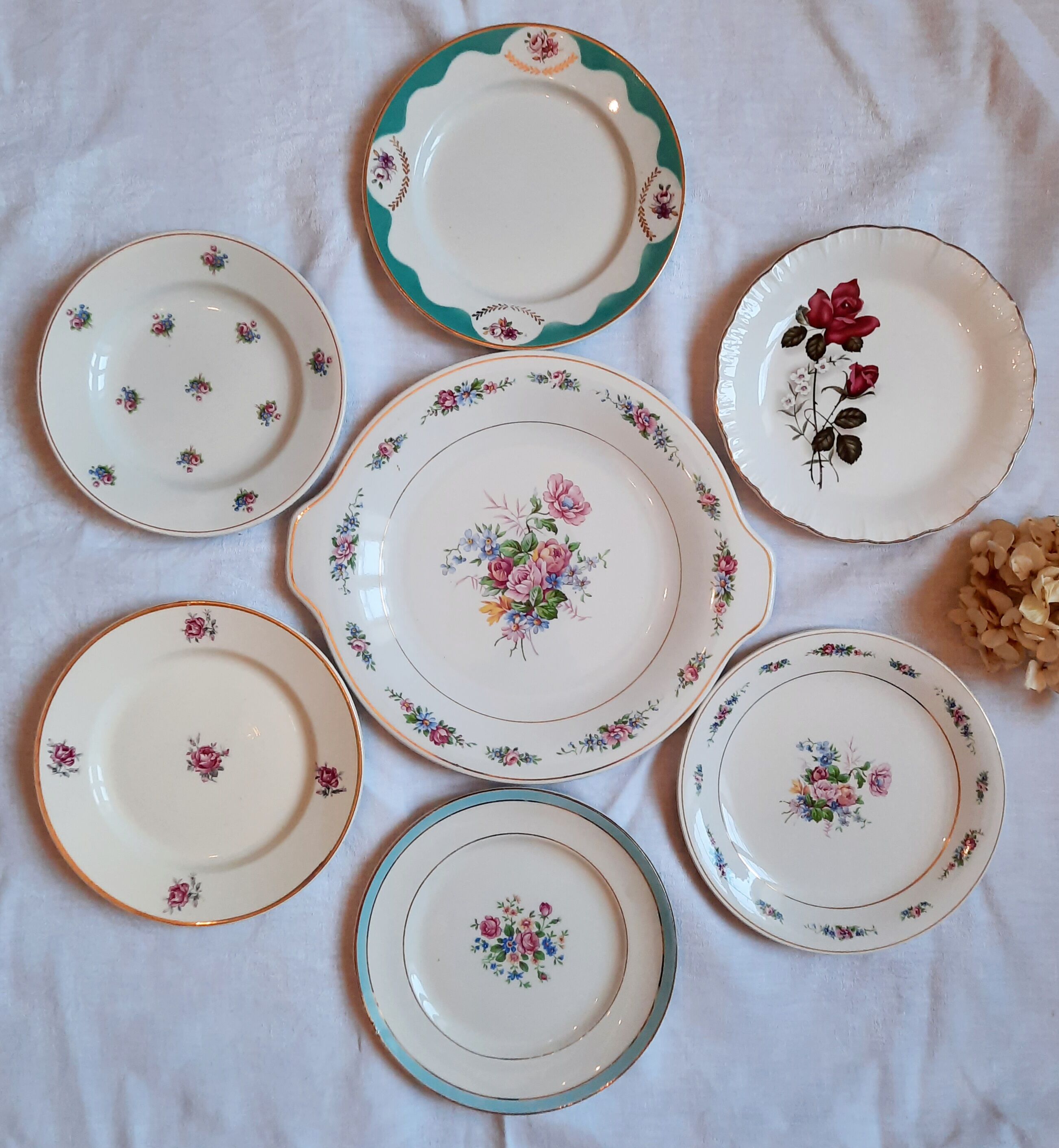 7 mismatched antique dessert plates accompanied by a pie dish