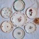 7 mismatched antique dessert plates accompanied by a pie dish