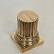 A pair of brass bookends representing columns.